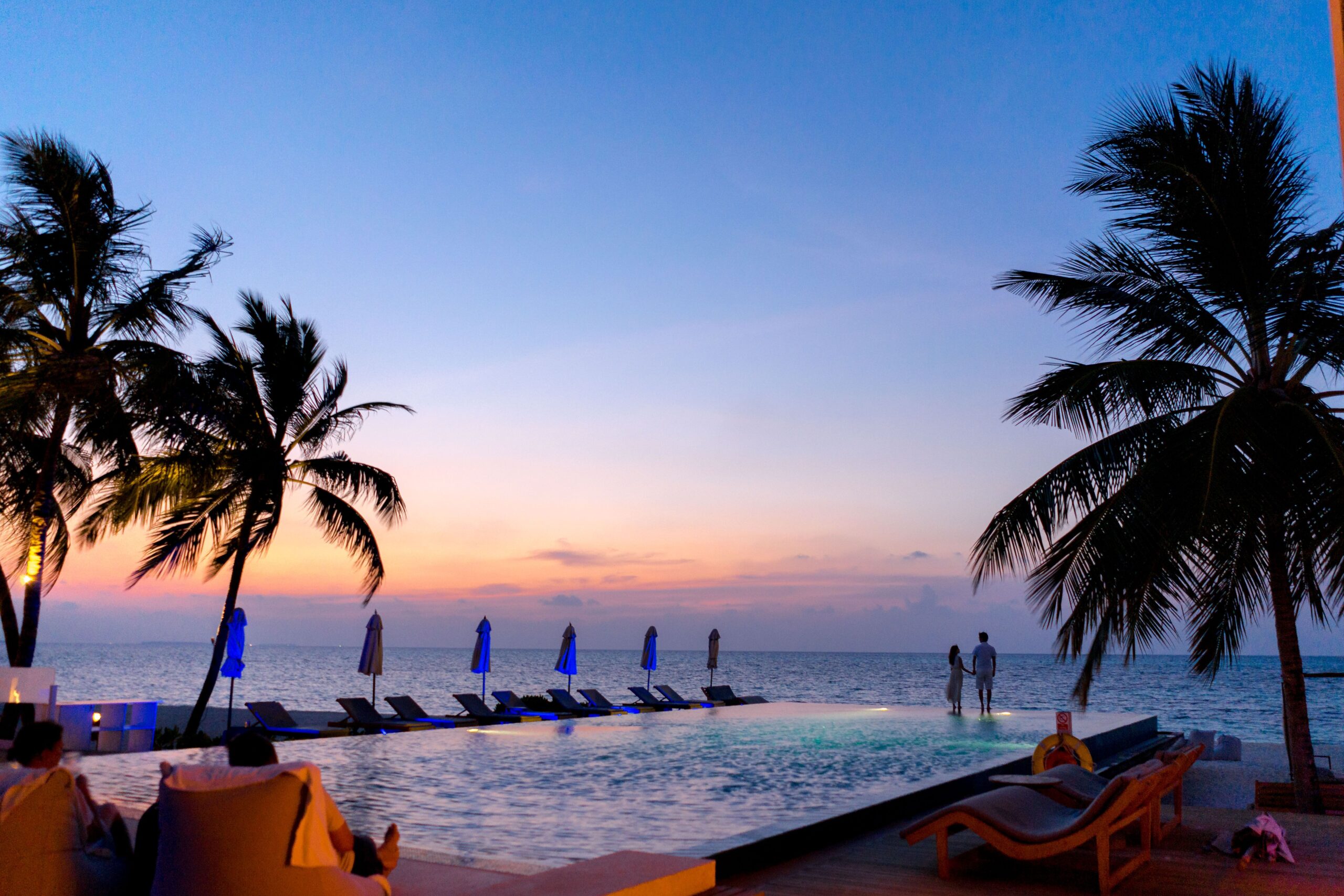 Palm trees silhouetted against a dramatic dusk sky, a reminder that travel plans meet real-world unpredictability