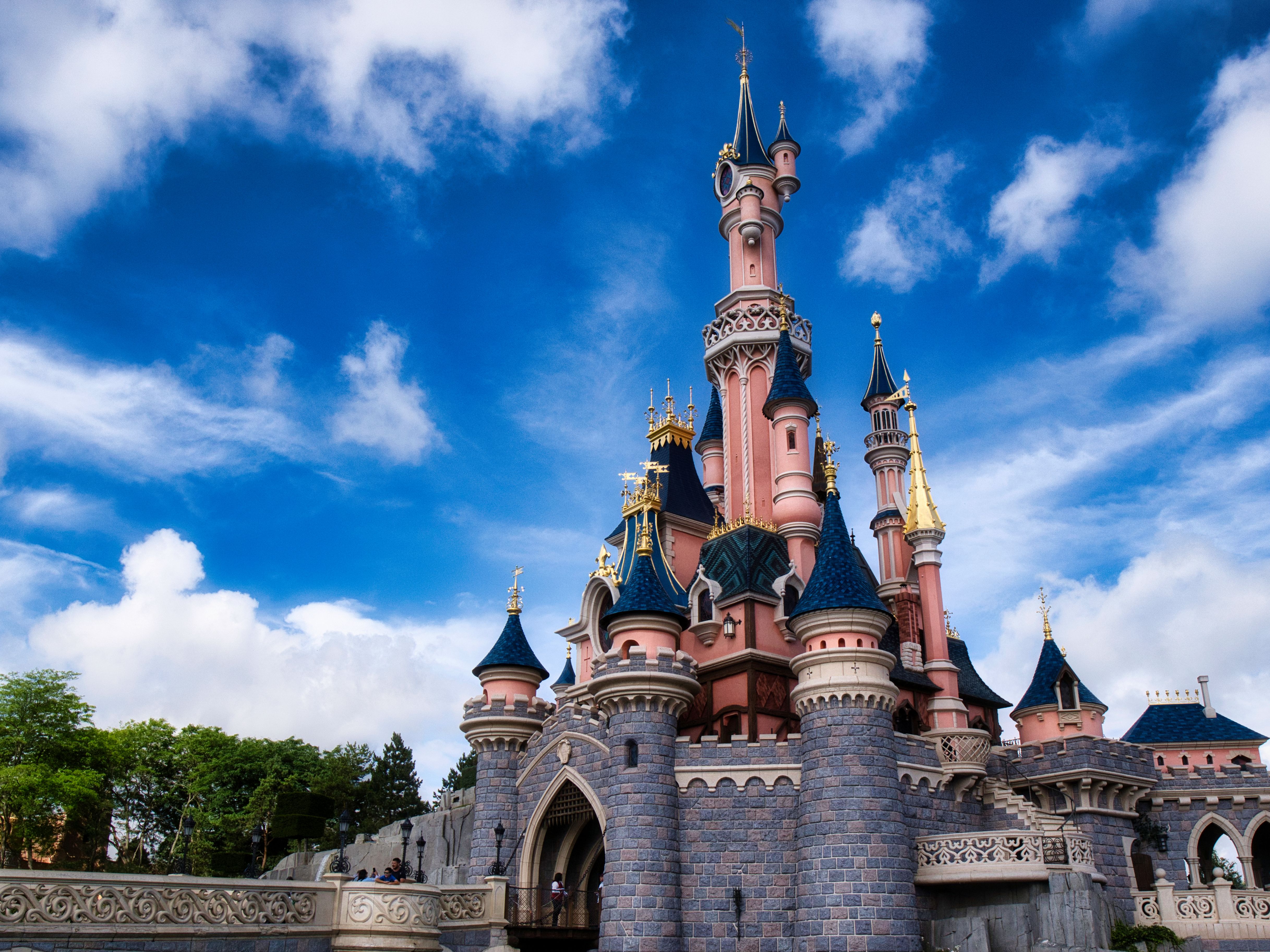 Fairytale castle at a Disney theme park under a blue sky